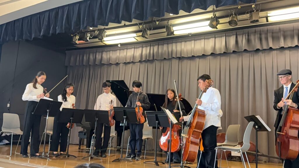 A student orchestral performance showcasing young musicians playing various string instruments, highlighting talent and collaboration on stage.